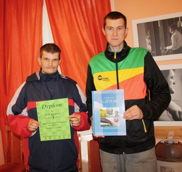 Mariusz Kobus i Artur Jurczak z dyplomem i książką