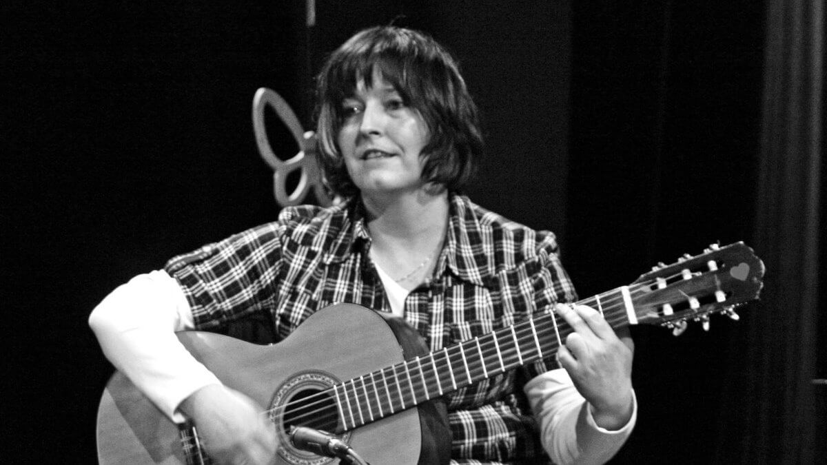 Czarno-białe zdjęcie Ani Czubały grającej na gitarze