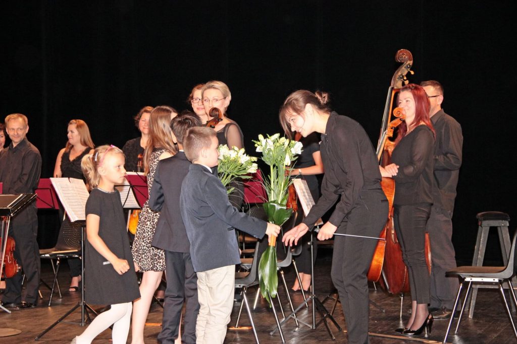 Muzycy odbierają kwiaty od dzieci