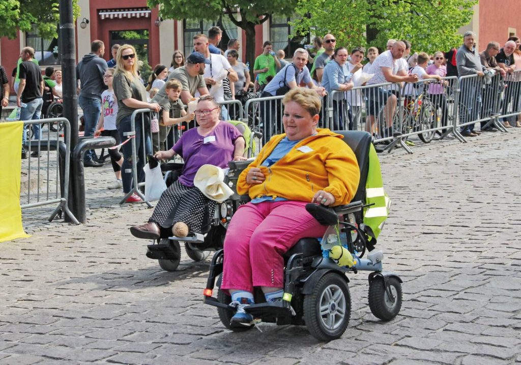 Zawodniczki jadą na elektrycznych wózkach inwalidzkich