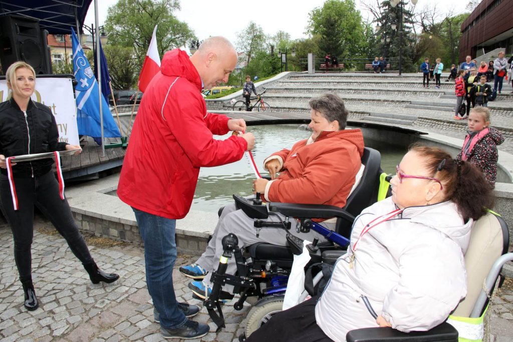 Wręczanie medalu kobiecie na wózku elektrycznym