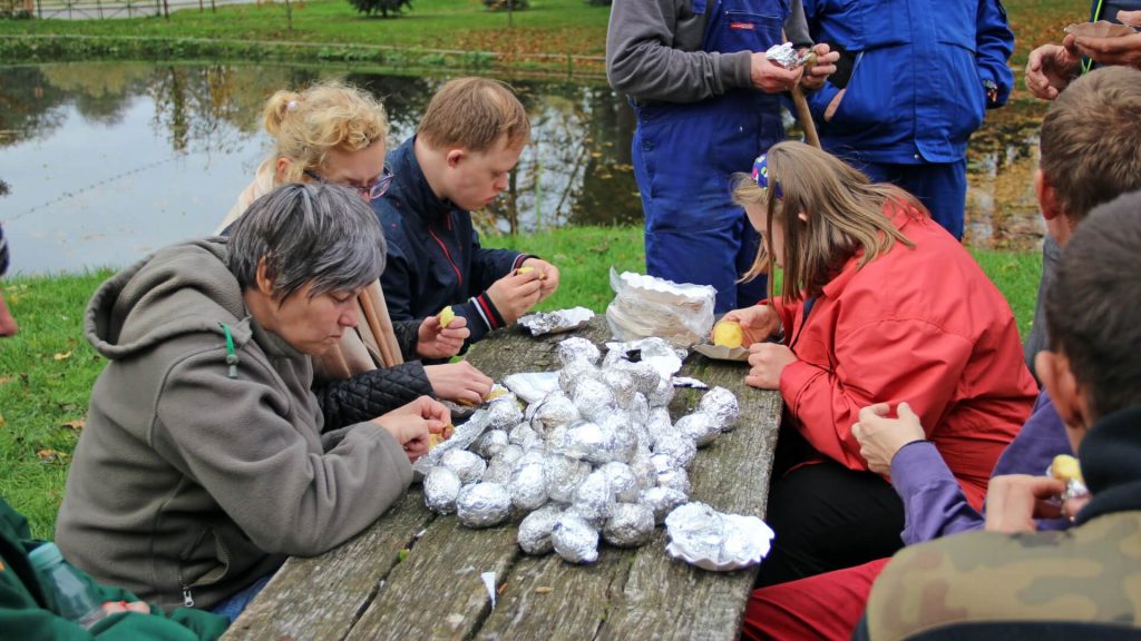 Uczestnicy Warsztatu Terapii Zajęciowej w Kwidzynie podczas jedzenia pieczonych ziemniaków