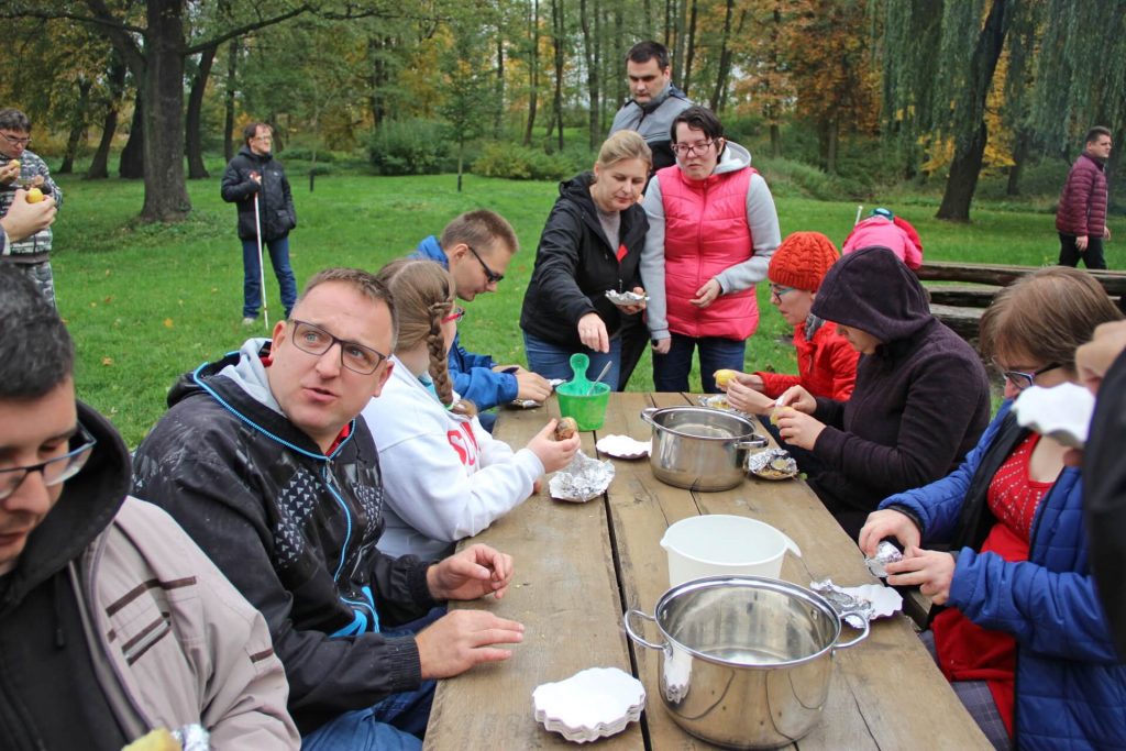 Uczestnicy Warsztatu Terapii Zajęciowej w Kwidzynie podczas jedzenia pieczonych ziemniaków