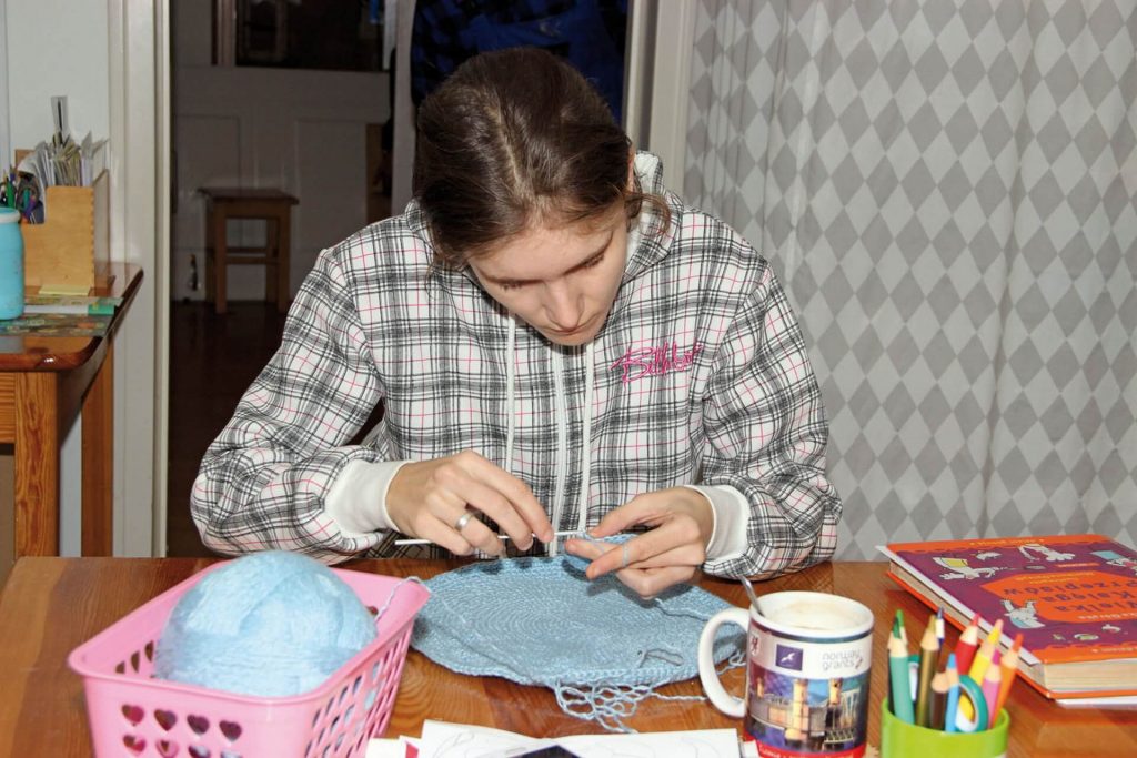 Uczestniczka Warsztatu Terapii Zajęciowej w Kwidzynie podczas robienia na drutach
