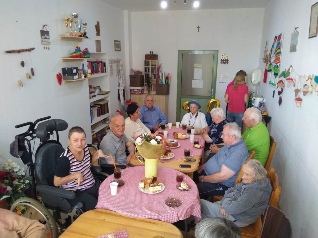 Seniorzy podczas spotkania przy ciastkach, kawie i herbacie