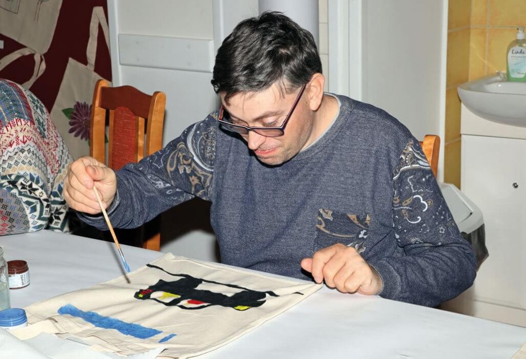 Uczestnik maluje na torbach na zakupy