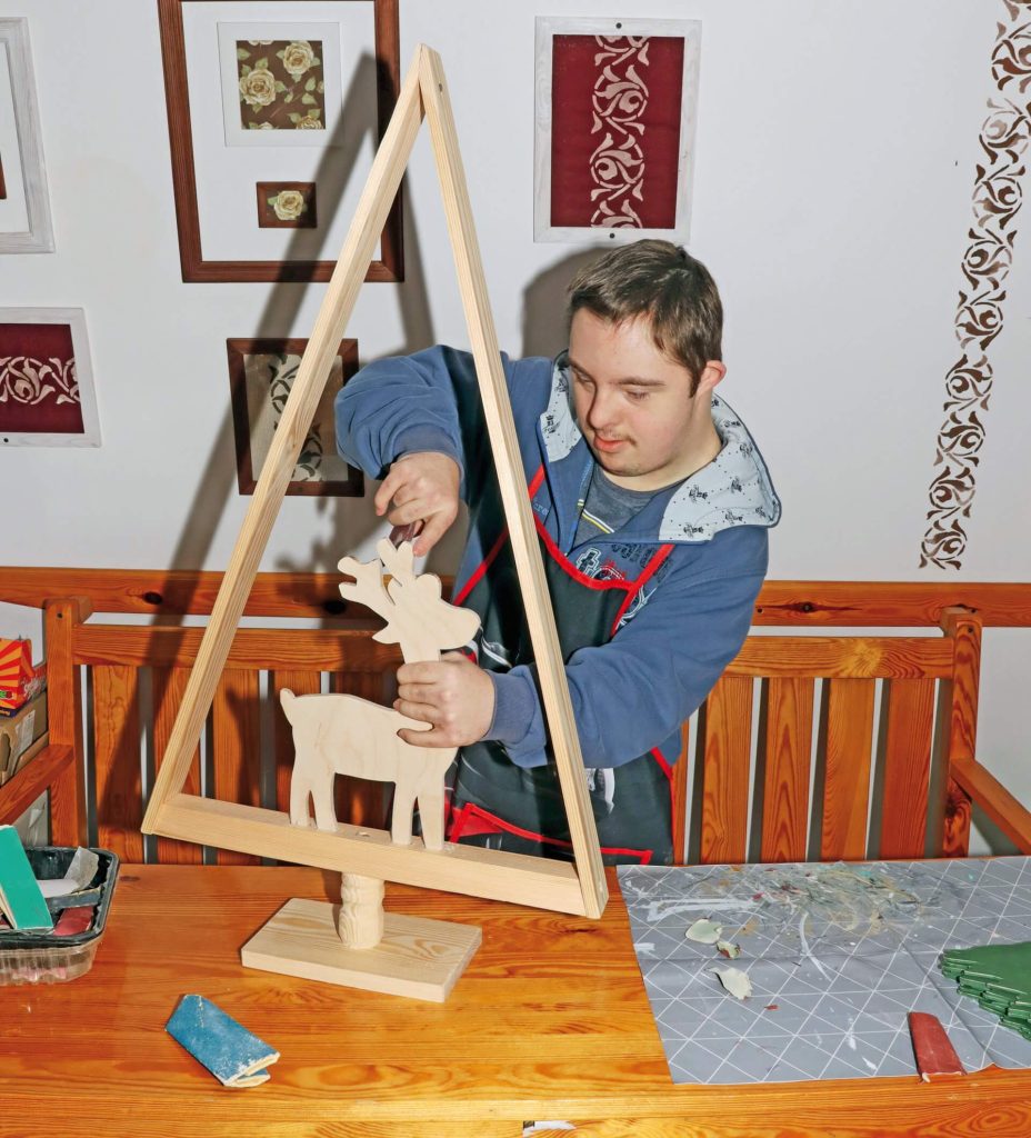 Uczestnik Warsztatu Terapii Zajęciowej w Górkach przygotowuje świąteczną ozdobę