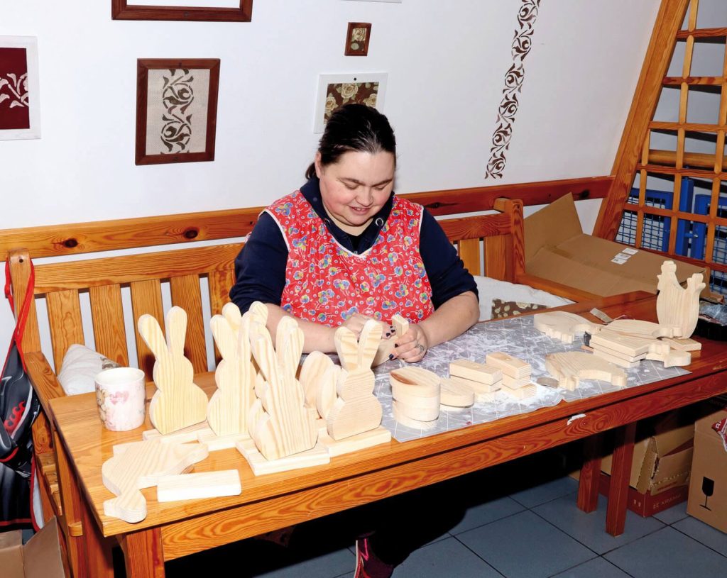 Uczestniczka Warsztatu Terapii Zajęciowej w Górkach przygotowuje wielkanocne ozdoby