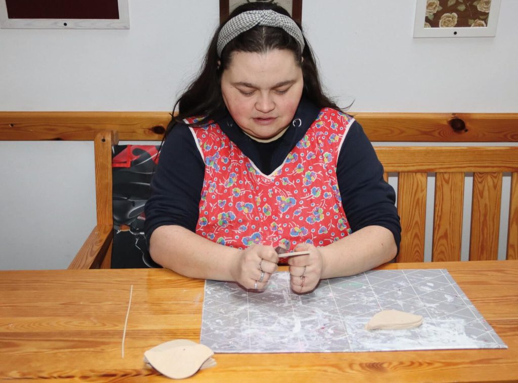 Uczestniczka Warsztatu Terapii Zajęciowej w Górkach przygotowuje wielkanocne ozdoby