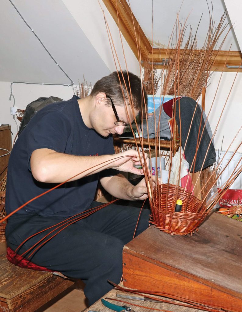 Uczestnik Warsztatu Terapii Zajęciowej w Górkach przygotowuje wielkanocny koszyk