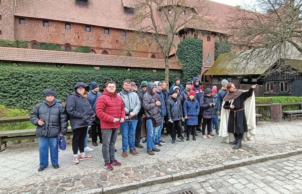 Zdjęcie grupowe uczestników przed malborskim zamkiem